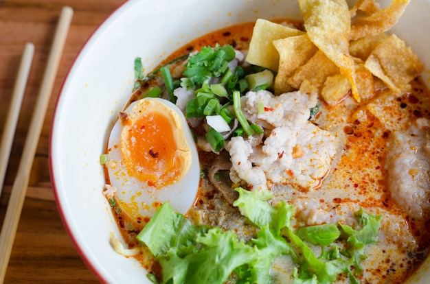 Premium Photo | Tomyum noodle with pork and egg