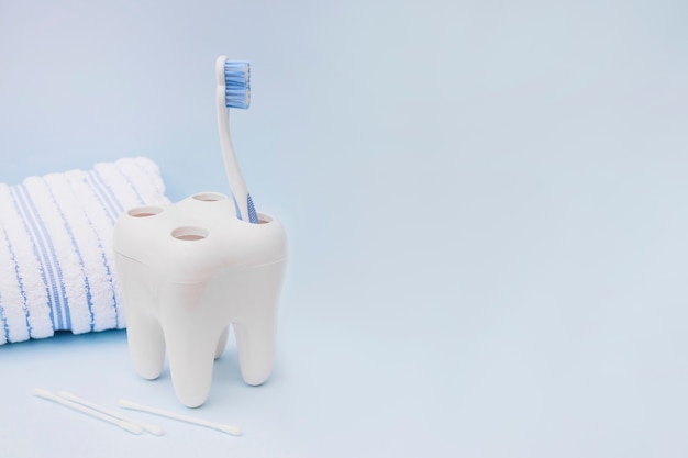 Toothbrush; cotton swab and towel on blue background Free Photo