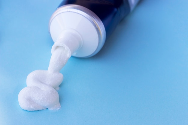 Premium Photo | Toothpaste squeezed out from tube on blue background ...