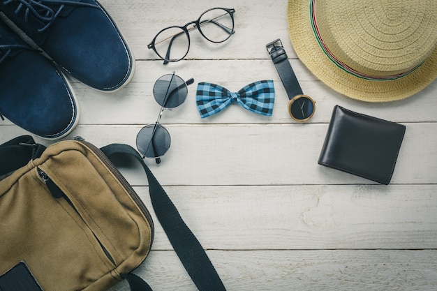 Free Photo | Top accessoires to travel with clothing concept. bow tie,wallet on wooden background.watch,sunglasses,bag,hat and on wood table.