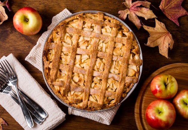 Top view of apple pie for thanksgiving with cutlery and leaves | Free Photo