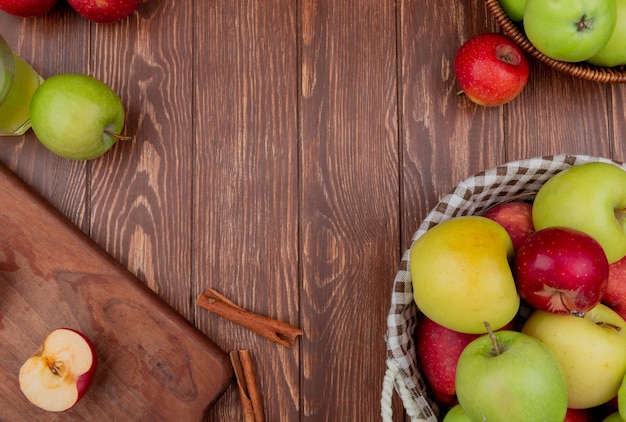 Free Photo Top View Of Apples In Baskets And On Cutting Board With Cinnamon Apple Juice On Wooden Background