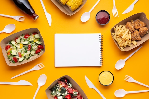 Top view arrangement with food, tableware and notebook Free Photo