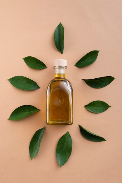Top view bottles filled with oil surrounded by leaves Free Photo