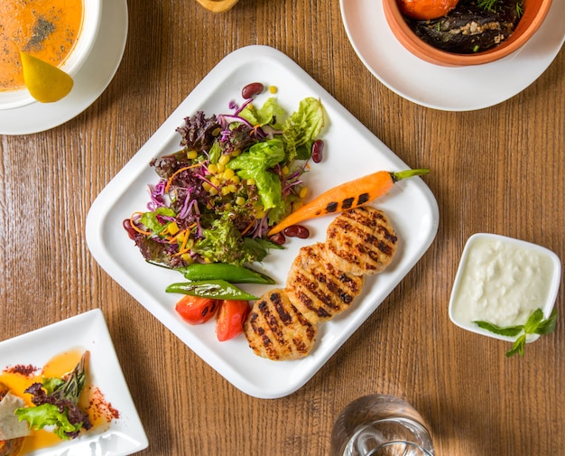 Top view chicken fillet cotlets and salad with yogurt. Free Photo