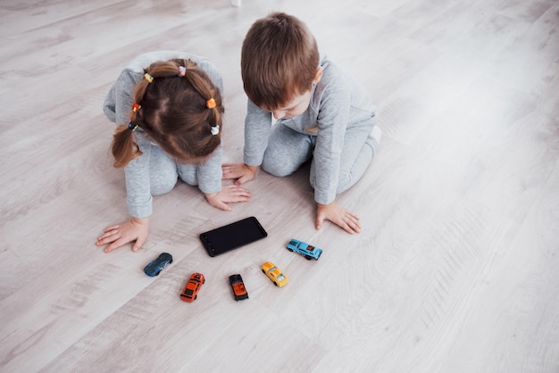 Top view. children using digital gadgets at home. brother and sister on pajamas watch cartoons and play games on their technology tablet Free Photo