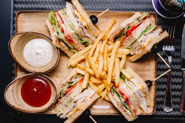 Top view of club sandwich served with french fries ketchup ...