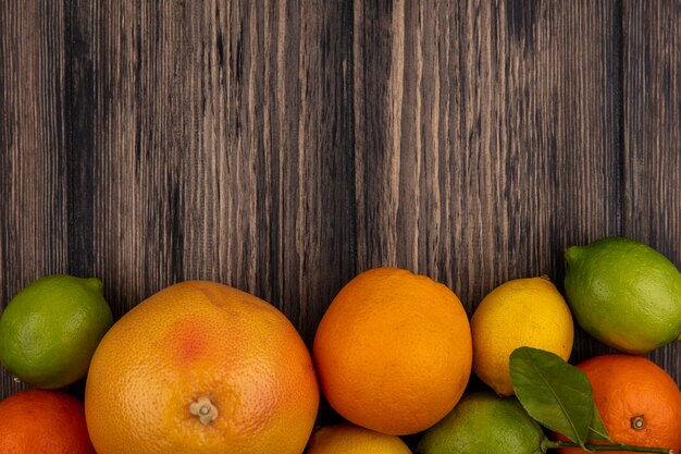 Free Photo Top View Copy Space Grapefruit With Oranges Lemons And Limes On Wooden Background