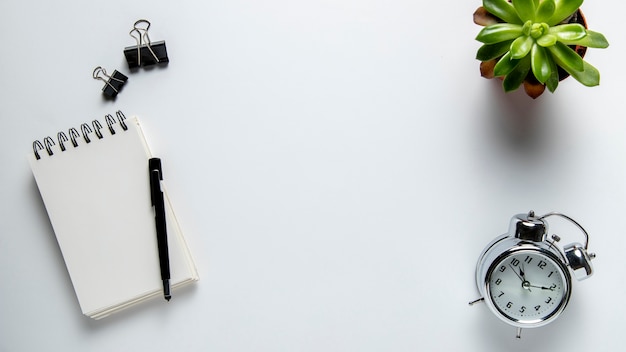 Top view desk with notepad and clock Free Photo