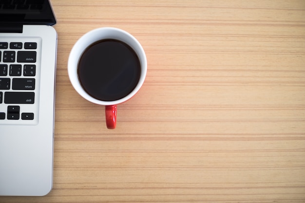 Top view desk work laptop and coffee cup notepad in home office. Free Photo