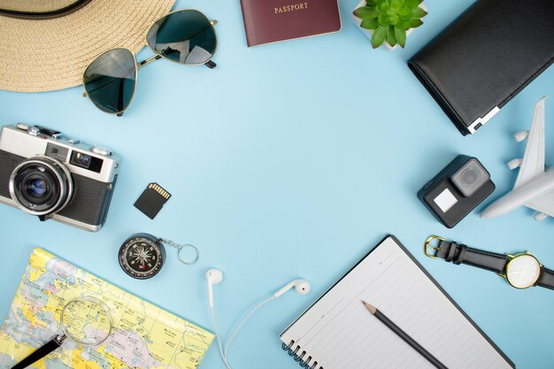 Top view, film camera, map, passport, smartphone, compass, sunglasses, notebook, purse with copy space. Premium Photo