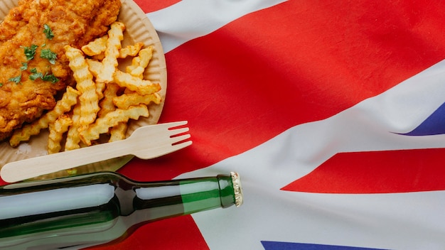 Free Photo | Top view of fish and chips on plate with beer bottle and