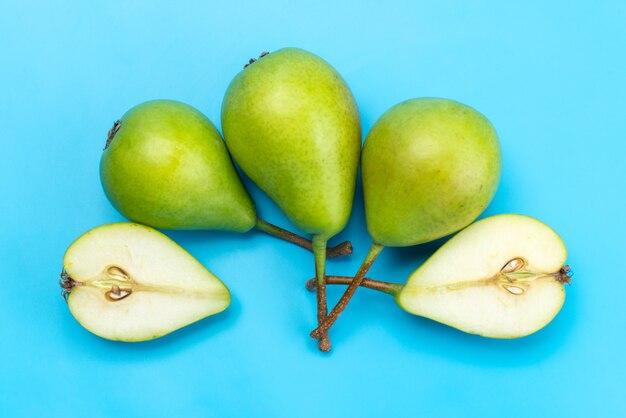 A top view green pears sliced and whole sweet and mellow on blue, fruit ...