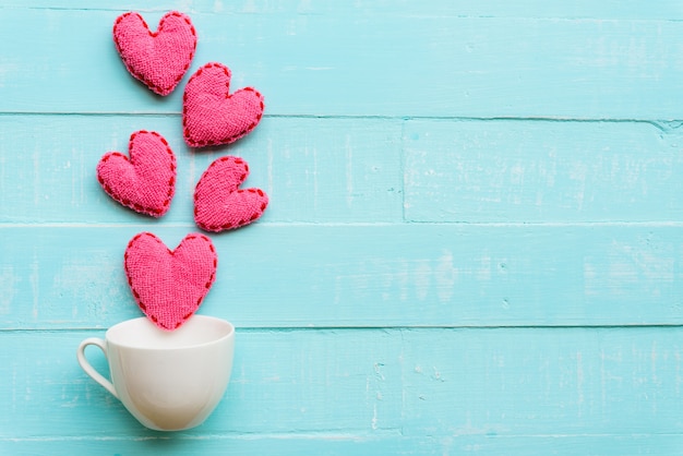 Top view of handmade pink heart on blue and white color wooden background Premium Photo