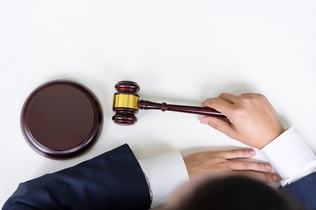 Top view of male judge and his hands holding the gavel at courtroom with copy spaces. justice and law. Premium Photo