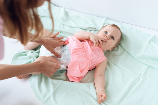 Premium Photo Top View Mom Giving Baby Diaper Change At Home