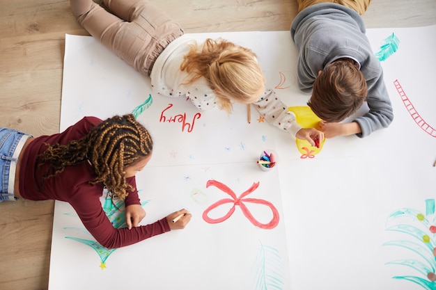 Premium Photo | Top view at multi-ethnic group of kids drawing pictures ...