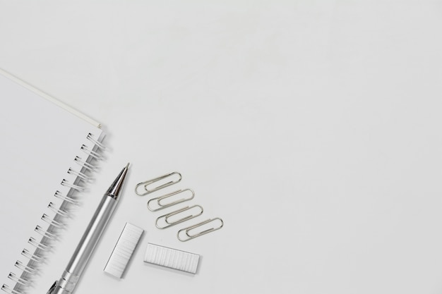 Top View Of Note Book Pen And Paper Clip Isolated On White