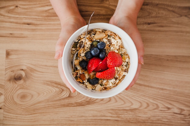 Premium Photo | Top view of person holding muesli bowl