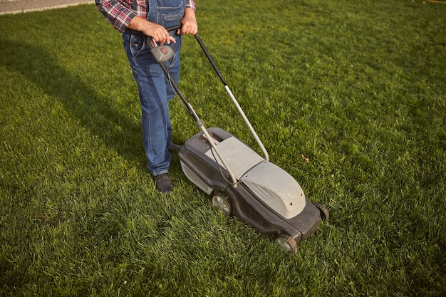 Premium Photo | Top view photo of a responsible gardener mowing a green ...