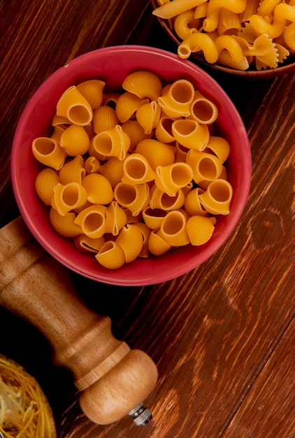 Download Free Photo Top View Of Pipe Rigate Pasta With Other Types Of Pasta In Bowls And Salt On Wooden Surface