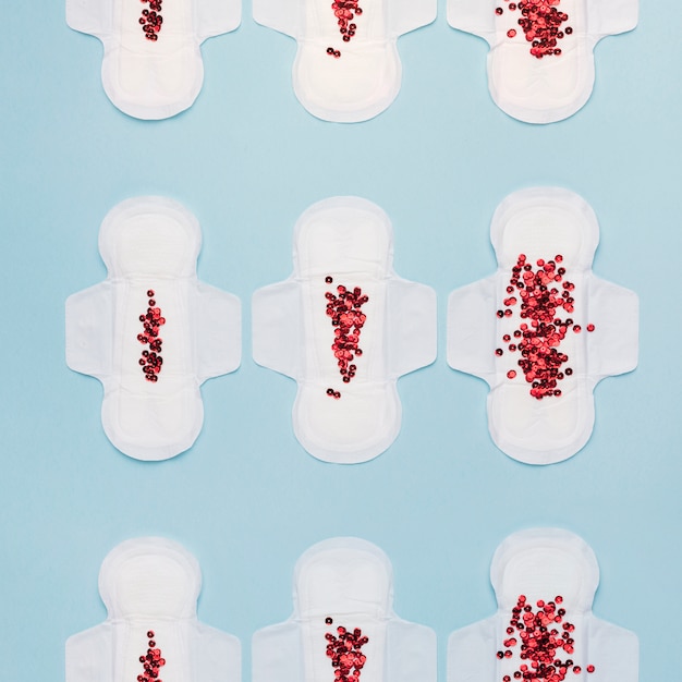 Top view sanitary towel lines with red sequins Free Photo