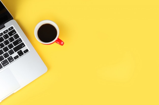 Top view of simple business office table with workspace laptop computer and red coffee cup Premium Photo