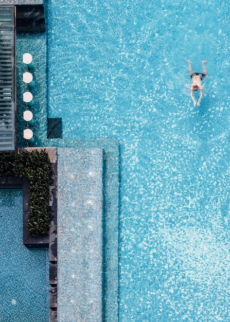 Premium Photo | Top view of swimming pool with floating bar and a man ...