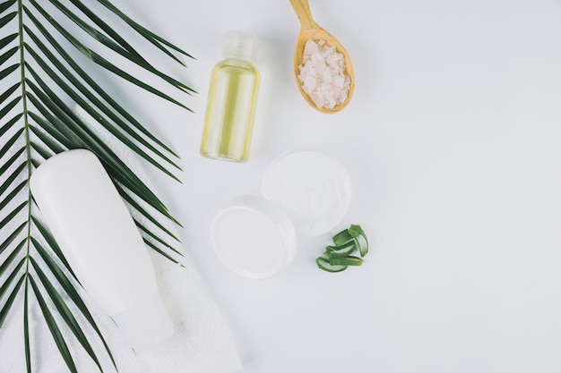 Top view tropical leaves with beauty tools and cosmetics Free Photo