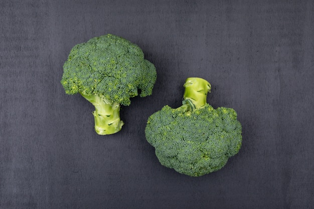 Free Photo Top view bunches of broccoli black surface
