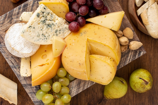 Top view variety of cheese with fruits Free Photo