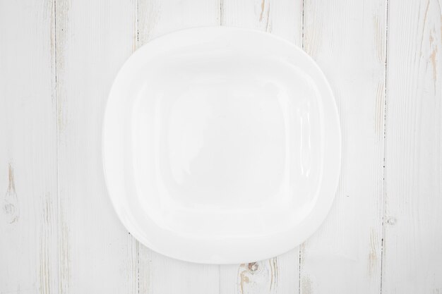 Premium Photo | Top view of a white plate on a wooden.