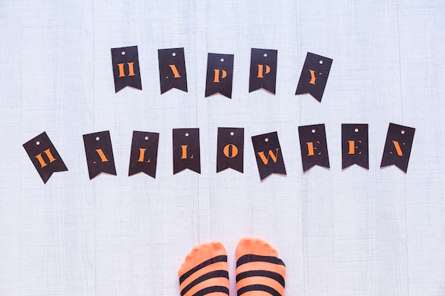 Premium Photo Top View Of A Woman Feet With A Happy Halloween Letters On The Floor Woman Wearing A Black And Orange Stripes Tights Concept Indoors And Lifestyle