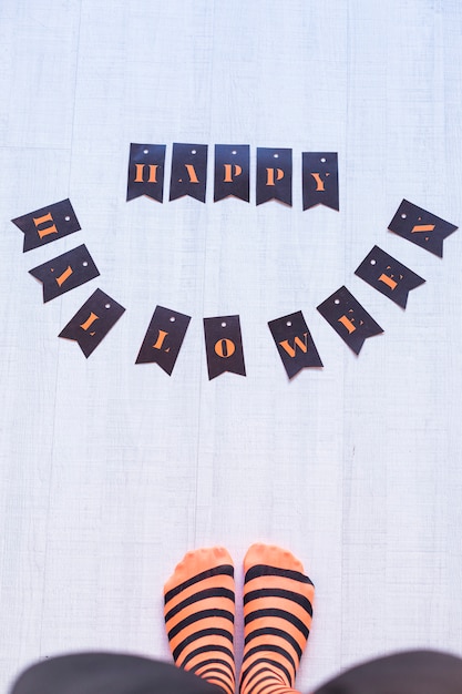 Premium Photo Top View Of A Woman Feet With A Happy Halloween Letters On The Floor Woman Wearing A Black And Orange Stripes Tights Concept Indoors And Lifestyle