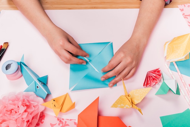 Top View Of Woman Hand Making Origami Craft Over Table Photo