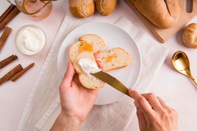 Free Photo | Top view woman spreading cream cheese on bread