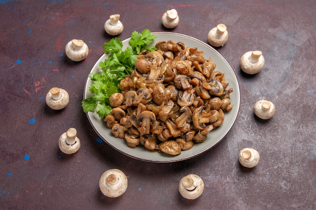 Free Photo | Top view yummy cooked mushrooms with greens on dark desk