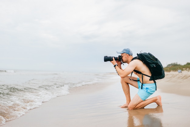 海の写真を撮る写真カメラでトップレスの旅行者 プレミアム写真