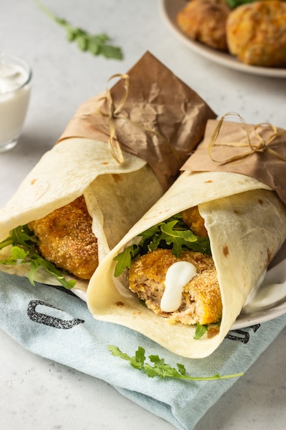 Premium Photo | Tortilla wraps with chicken or turkey cutlets, arugula ...