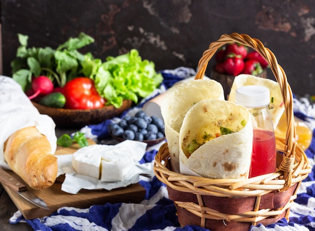 Tortilla wraps with roasted chicken and vegetables, juices, vegetables and berries, baguette and cheese. Premium Photo