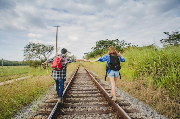 Tourist Couple Holding Hands On Train Tracks Photo Free