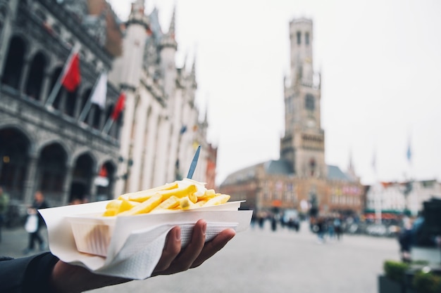 Premium Photo Tourist Holds Popular Street Junk Food French Fries In