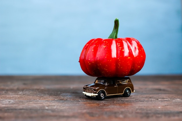 Premium Photo | A toy car with big orange pumpkin autumn harvesting concept