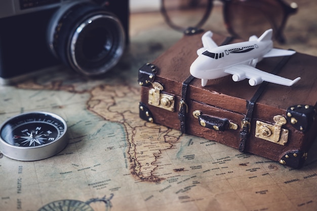Toy plane and suitcase on vintage map with copy space Premium Photo