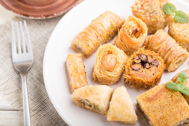 Traditional arabic sweets (kunafa, baklava) and a cup of coffee on a ...