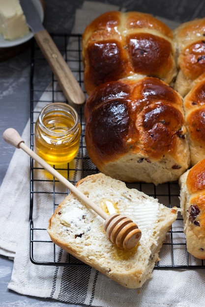 Premium Photo | Traditional hot cross buns with honey and butter on a ...