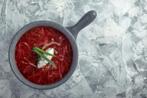 ボウルにサワークリームと伝統的なウクライナロシアボルシチ 灰色の大理石の赤いビーツスープボルシチのプレート 伝統的なウクライナ料理 プレミアム写真