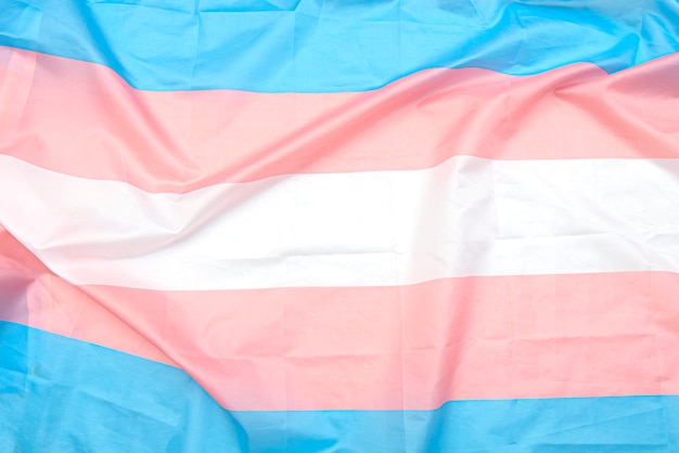 白 ピンク 青の帯を持つトランスジェンダー生地の旗 背景やテクスチャとしてトランスジェンダーのプライドフラグをクローズアップ プレミアム写真