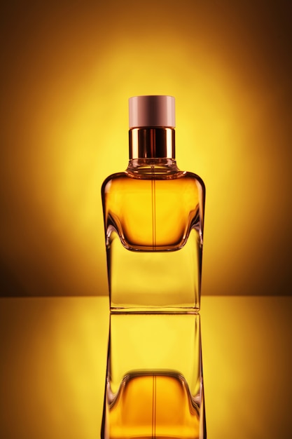 Premium Photo | Transparent bottle with perfume of gold color on a yellow