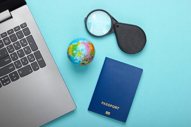 Premium Photo Travel Still Life Online Booking Emigration Laptop Globe And Passport Tourist Accessories On Blue Background Top View